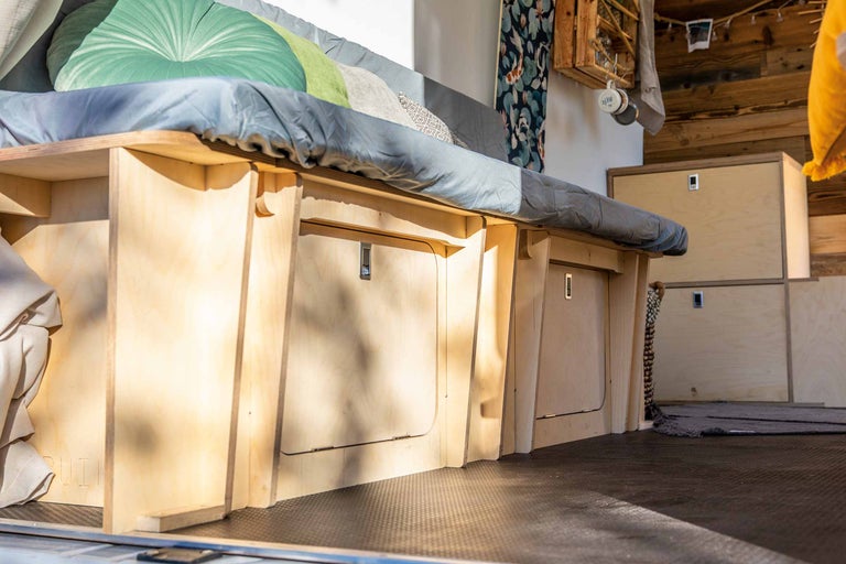 Innenausbau eines Kastenwagens mit Bett, Stauraum und Holzverkleidung