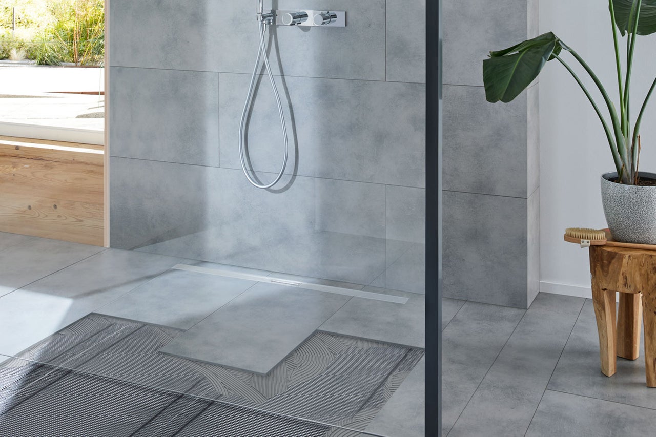 Modernes Badezimmer mit Dusche, grauen Fliesen und Fußbodenheizung.