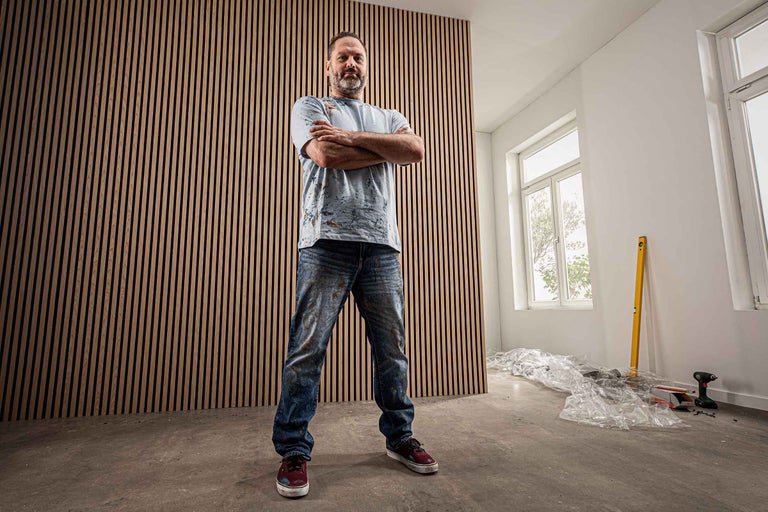 Raum mit Holzpaneelwand und stehendem Mann