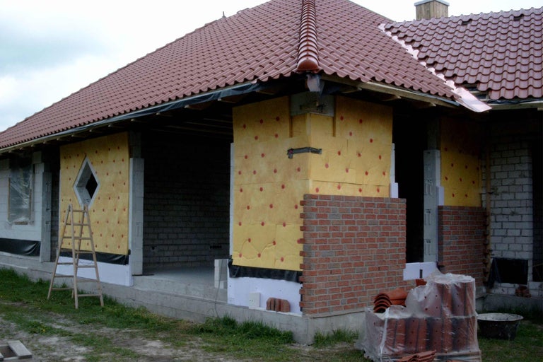Rohbau mit Dachziegeln, Isolierung und Mauerwerk im Bau