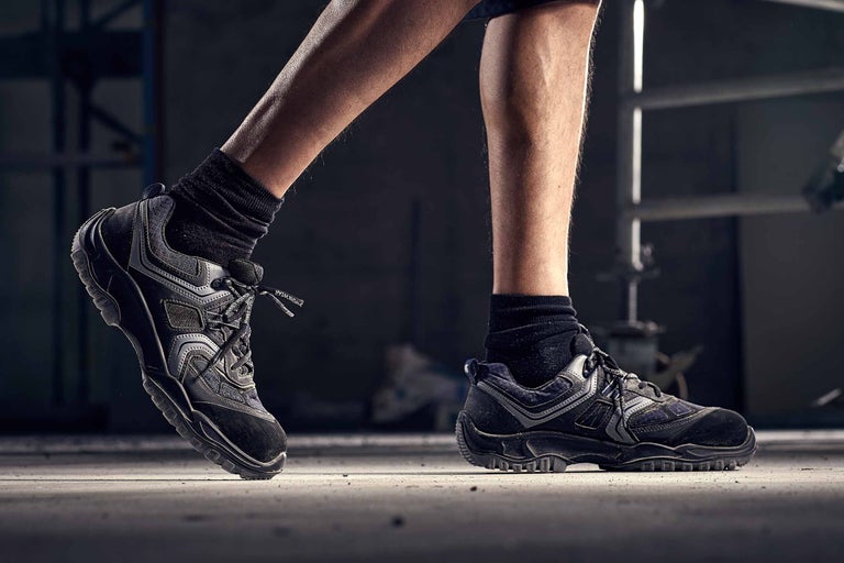 Nahaufnahme von Arbeitsschuhen an den Füßen einer Person