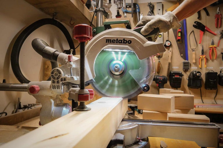 Metabo Kapp- und Gehrungssäge beim Schneiden eines Holzstücks in einer Werkstatt.