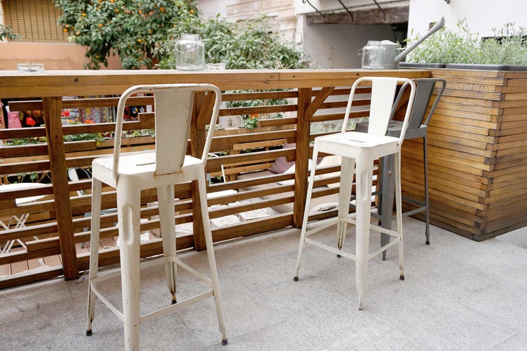 Außenbereich mit Barhockern aus Metall und Holztisch