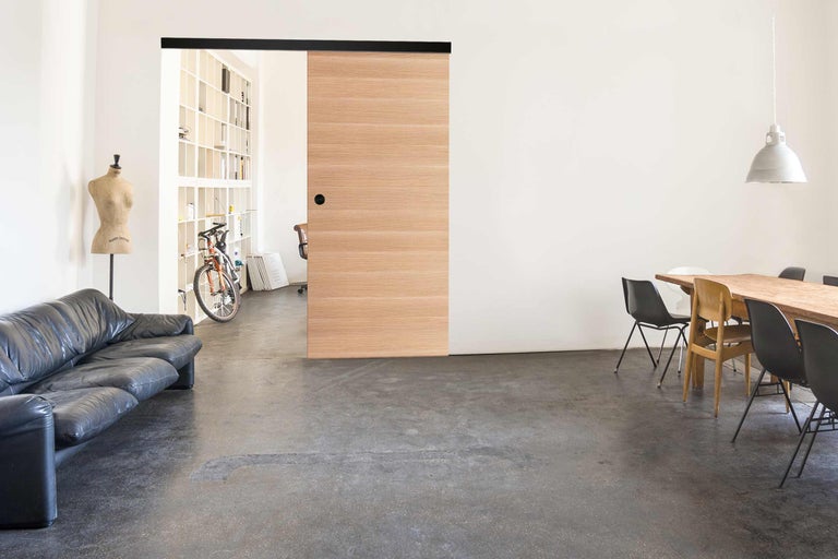 Heller Wohnraum mit Schiebetür, Esstisch und Sofa.