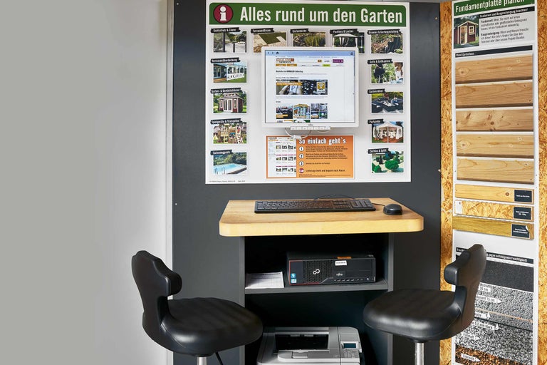 Informationsstand im Hornbach Markt mit Hinweisen zu Gartenprodukten, Computerterminal, Schreibtisch, Stühlen und Produktmustern