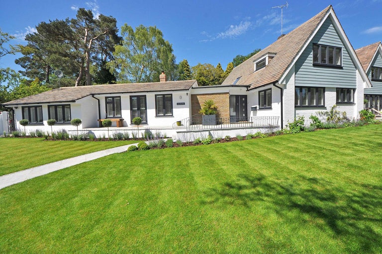 Ansicht eines Wohnhauses mit Garten und Rasenfläche