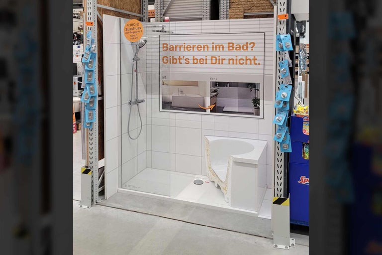 Ausstellungsstück mit bodengleicher Dusche und Badewannenmodell zur Veranschaulichung eines barrierefreien Badezimmers