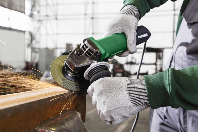 Eine Person benutzt einen Trennschleifer der Marke Hikoki zum Schneiden von Metall, wobei Funken entstehen.