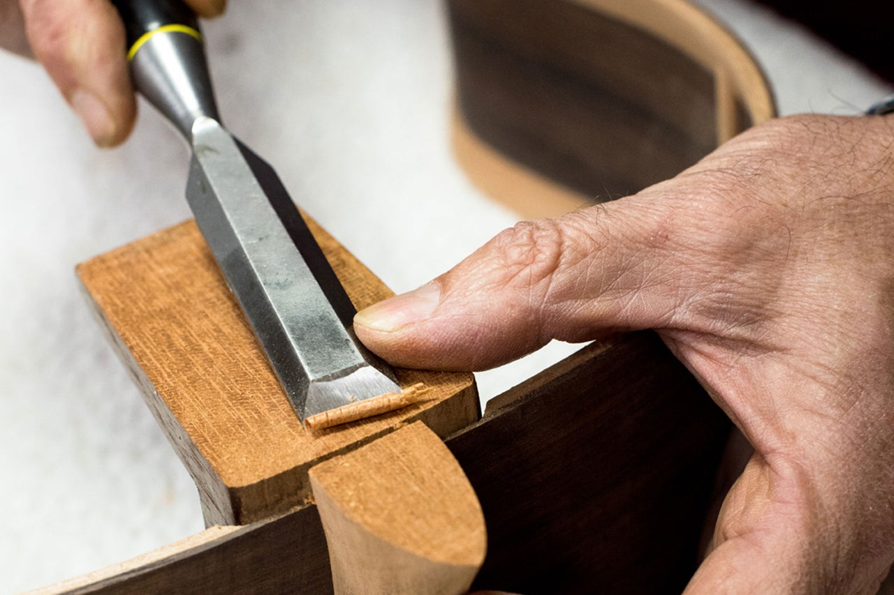 Handwerker bearbeitet Holz mit Stechbeitel