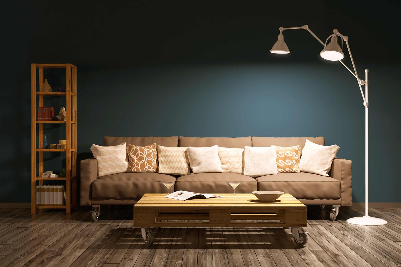 Wohnzimmer mit Sofa, Stehlampe und Regal