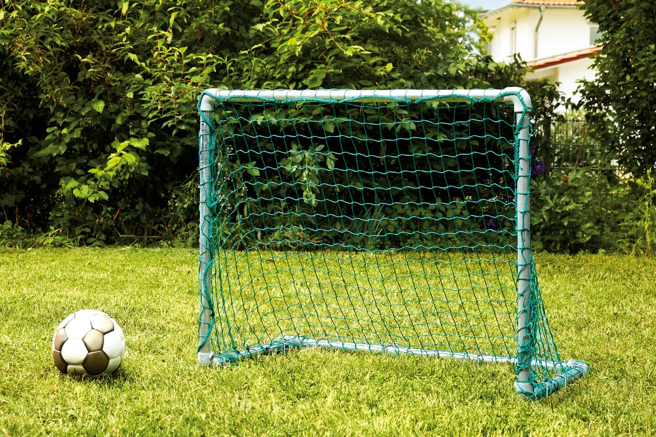 Fußballtor mit Fußball auf Rasen
