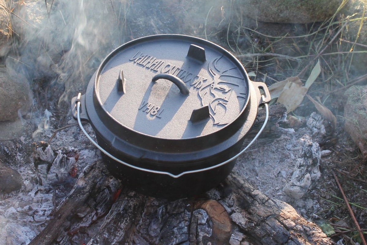 Gusseiserner Topf mit Deckel auf Lagerfeuerstelle