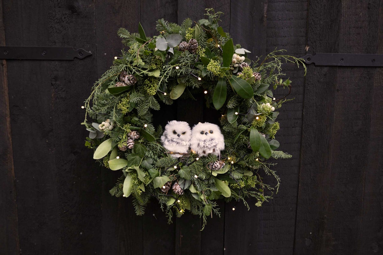 Weihnachtlicher Türkranz mit Tannenzweigen, Blättern, Zapfen, Lichtern und zwei Deko-Eulen