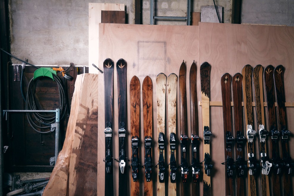 Auswahl von Klaus’ Ski mit Holzdekor an eine Holzwand gelehnt. Auswahl von Klaus’ Ski mit Holzdekor an eine Holzwand gelehnt.
