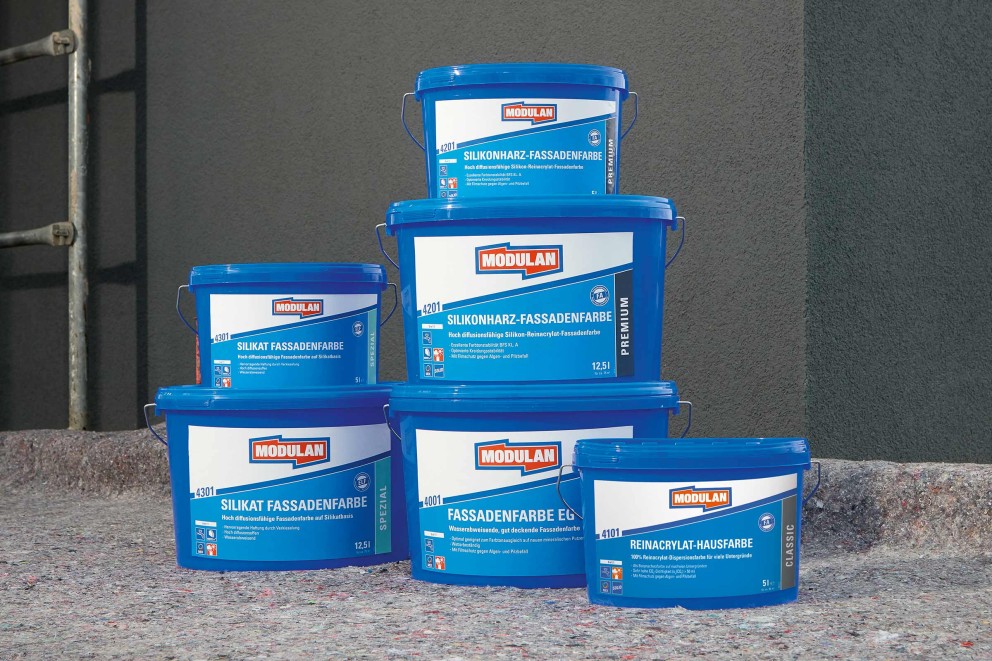 Produktübersicht von Modulan Fassadenfarben, inklusive Silikat Fassadenfarbe, Silikonharz Fassadenfarbe und Reinacrylat Hausfarbe in blauen Eimern