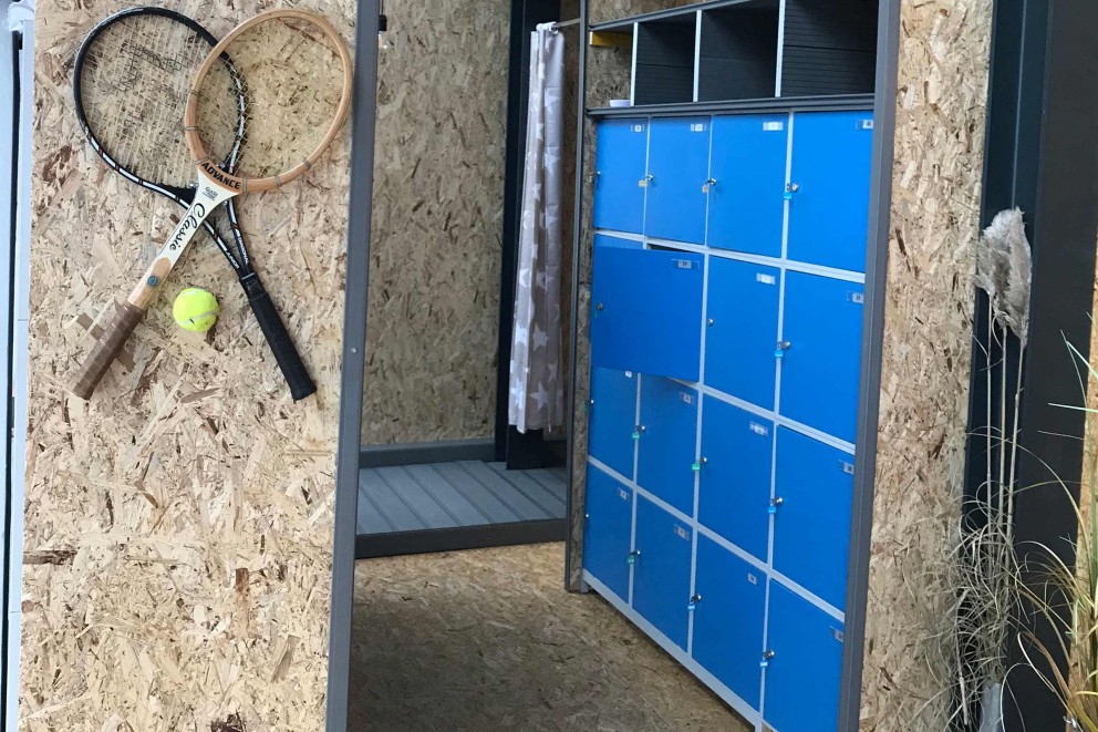 
				Blaue Schließfächer sind in einem selbstgebauten Schrank aus OSB Platten eingefasst.

			