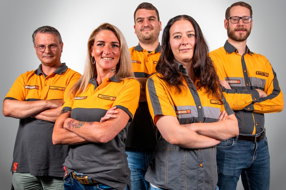 Eine Gruppe von Hornbach Mitarbeitern in Arbeitskleidung posiert für ein Foto.