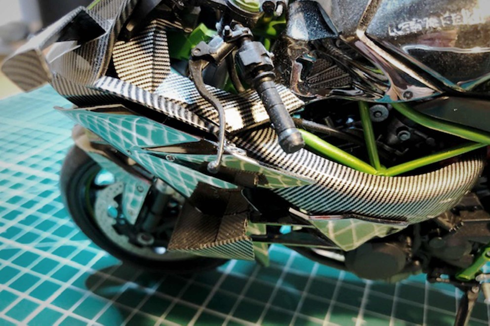 Detailansicht eines Motorrads mit Carbon-Verkleidung und grünen Akzenten.