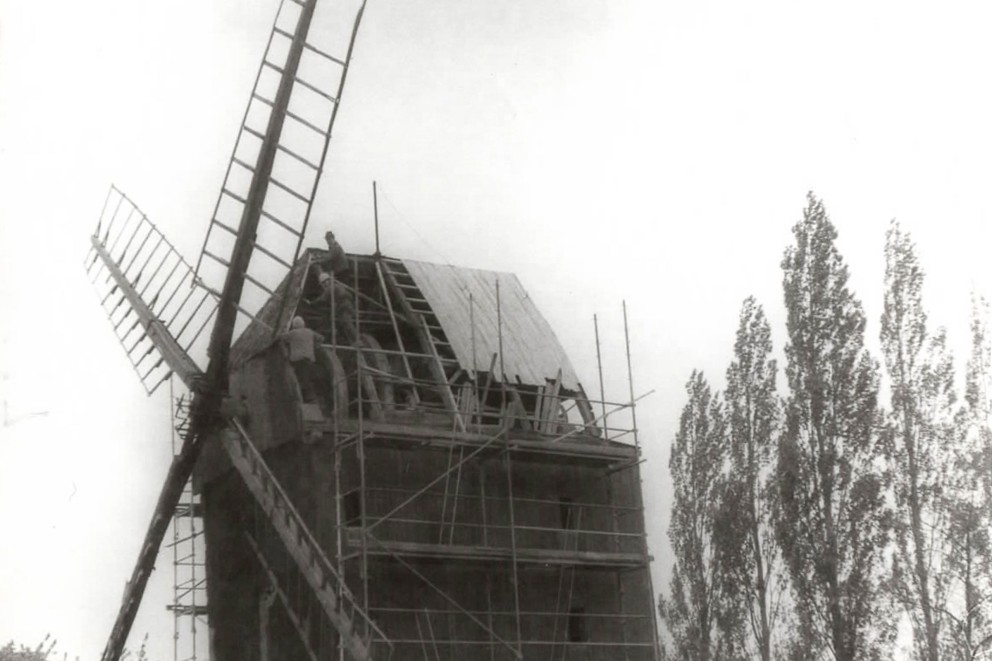 
				April 1990: Die Mühle wird das erste Mal eingerüstet. Neue Dachlatten werden angebracht.

			