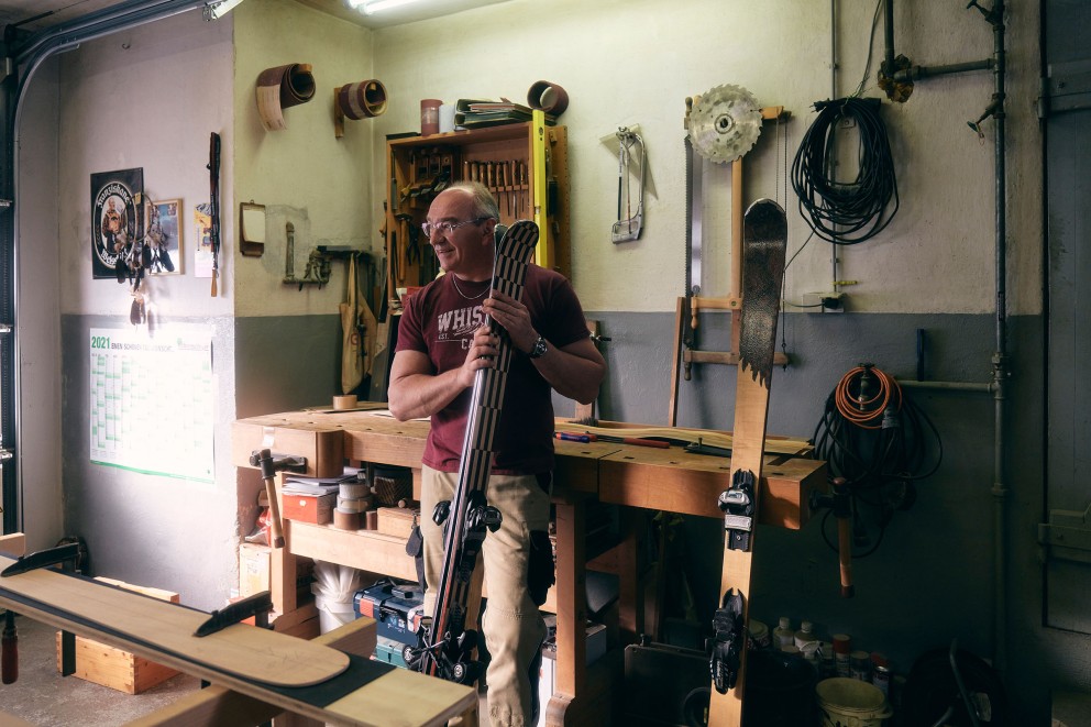 Klaus mit einem Paar Ski im Arm in seiner Werkstatt. Klaus mit einem Paar Ski im Arm in seiner Werkstatt.