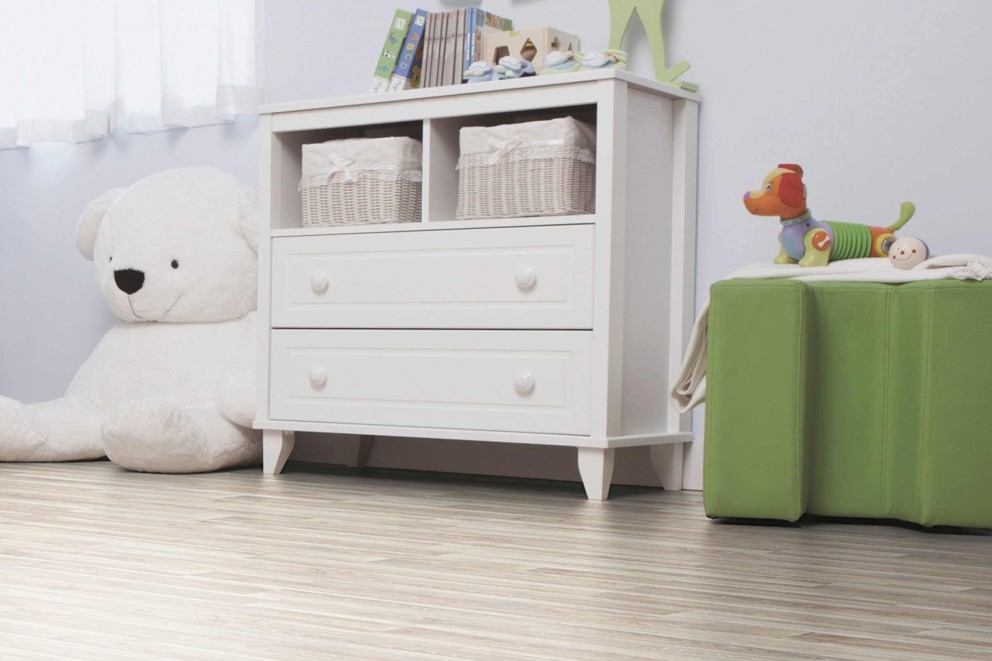 Kinderzimmer mit weißer Kommode, Spielzeug und Holzboden