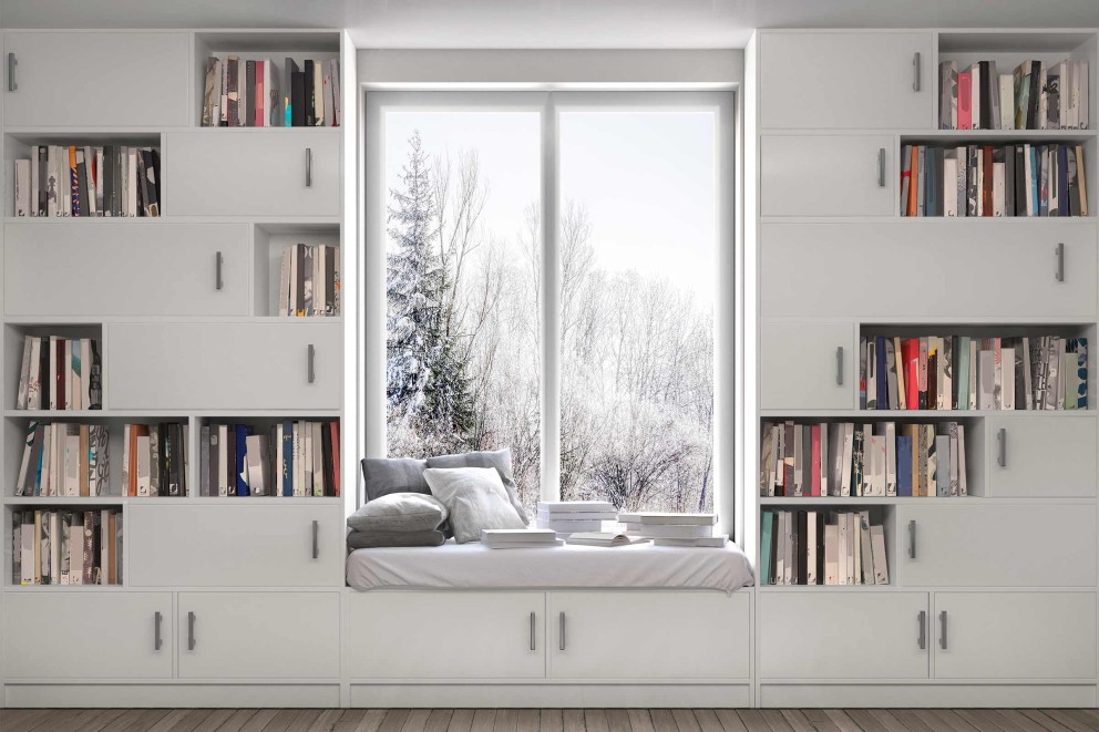 Weißes Bücherregal mit Fensterplatz, Kissen und Büchern