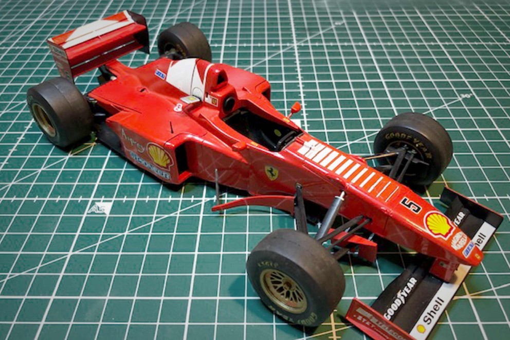 Rotes Formel-1-Modellauto auf einer Schneidematte