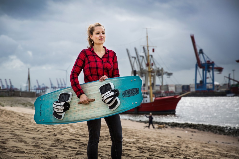 Autorin Esther Acason steht mit dem selbst gebauten Kiteboard unterm Arm am Hamburger Elbstrand Autorin Esther Acason steht mit dem selbst gebauten Kiteboard unterm Arm am Hamburger Elbstrand