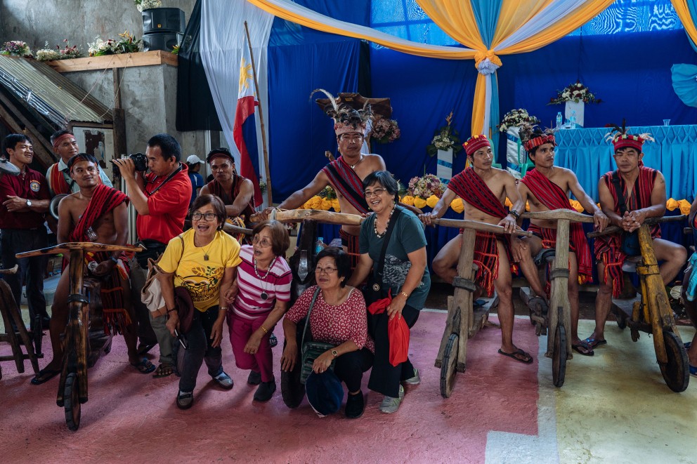 
				Die Männer des Ifugao Stammes auf den Philippinen posieren stolz mit ihren selbst gebauten Holzrollern für die Touristen

			