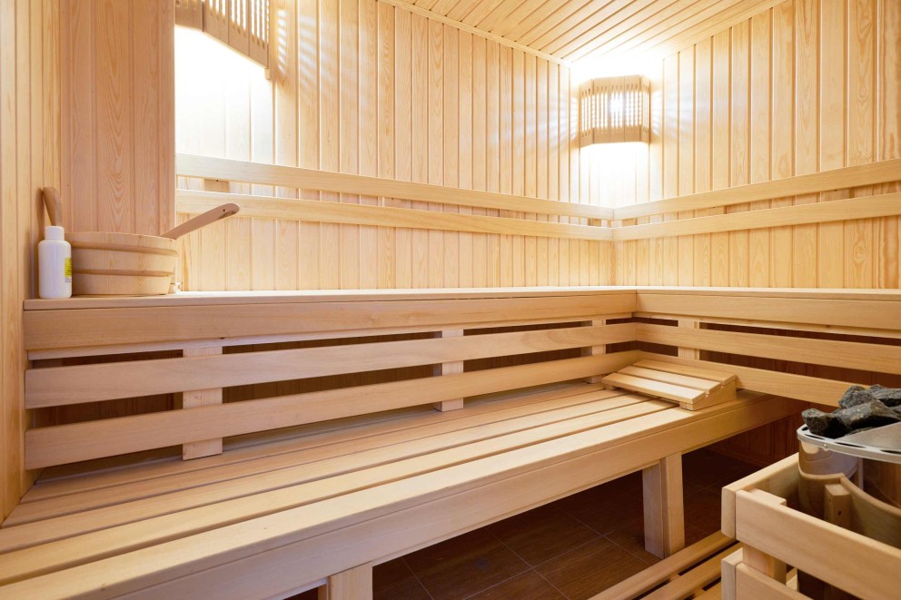 Helle Holzsauna mit Bänken, Holzwand und Sauna Zubehör