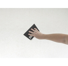 Hand mit Schleifpapier an einer Wand