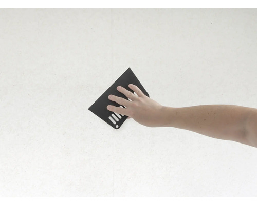 Hand mit Schleifpapier an einer Wand