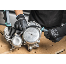 Hände mit Handschuhen arbeiten an einem Sachs Motor mit Schraubenzieher