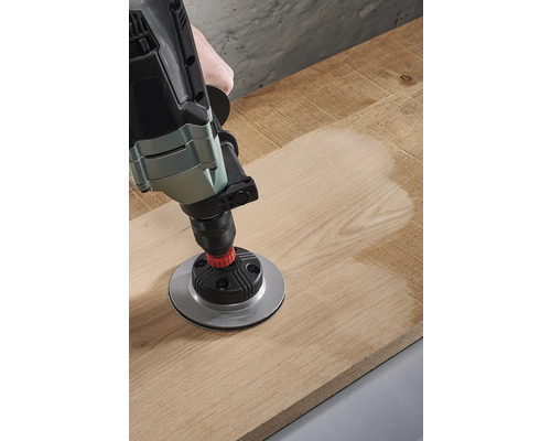 Bohrmaschine mit Schleiftelleraufsatz bearbeitet Holzoberfläche