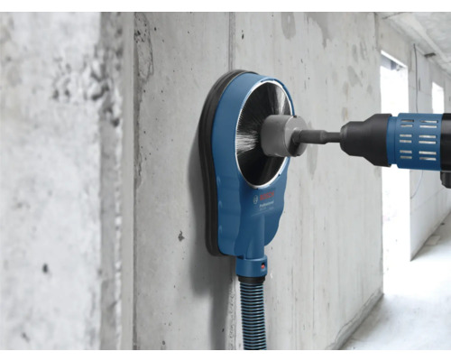 Bosch Sanierungsschleifer mit Bürstenkranz und Staubsauger an einer Betonwand.