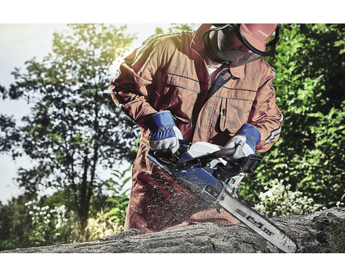 Mann mit Schutzkleidung sägt Holz mit einer Kettensäge