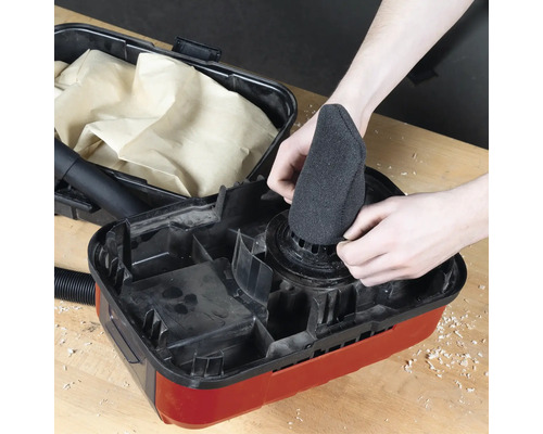 Ein Mann setzt einen Filter in einen Staubsauger.