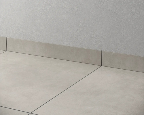 Bodenfliesen und Sockelleisten aus Feinsteinzeug an einer Wand