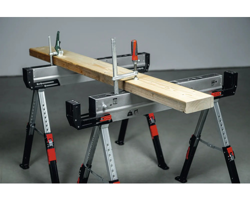 Zwei verstellbare Werkzeugböcke mit einer Holzplanke, die mit Schraubzwingen befestigt ist