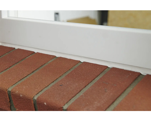 Detailaufnahme von Ziegelsteinen und einer Fensterbank