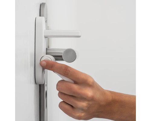 Eine Person betätigt eine Türgarnitur mit Drehknopf