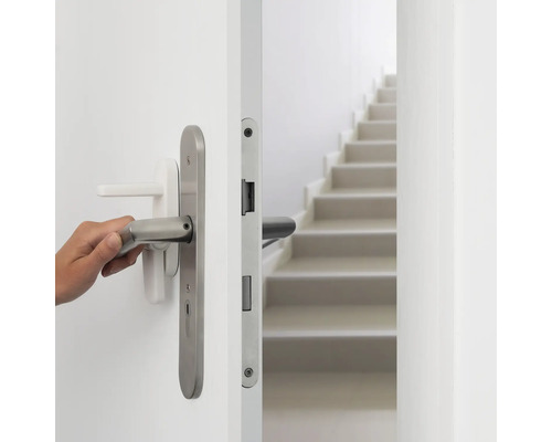 "Eine Hand öffnet eine weiße Tür mit einem silberfarbenen Türgriff