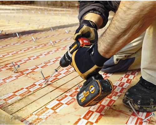 Handwerker befestigt Holzdiele mit einem Akkubohrer