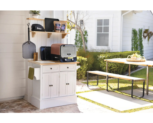 Außenküche mit Grill, Kochutensilien und Gartentischgruppe