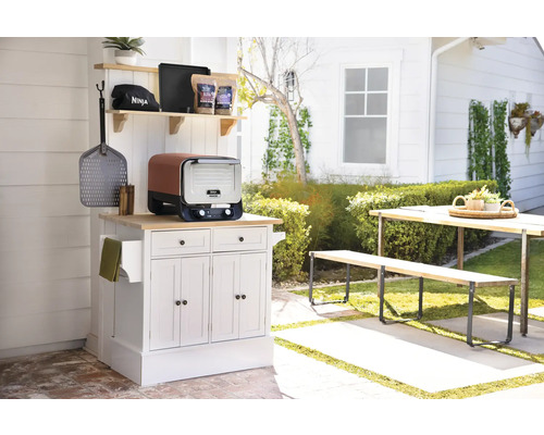 Szene mit einem Ninja Toaster auf einem weißen Küchentisch im Freien mit Gartentisch und Gartenbank