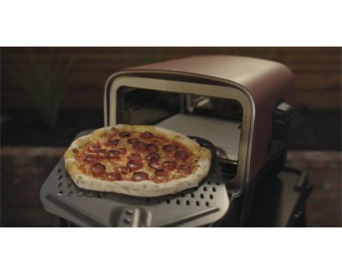 Pizza auf einem Pizzaschieber vor einem Pizzaofen