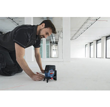 Handwerker markiert mit einem Linienlaser einen Boden in einem Rohbau