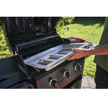 Ein Mann setzt eine Grillkohleschale in einen Gasgrill für Holzkohle