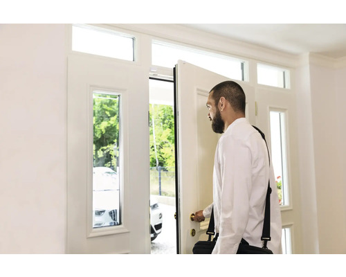 Mann öffnet eine weiße Haustür mit Fenster