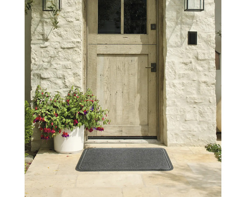 Außenbereich mit grauer Fußmatte vor einer Haustür